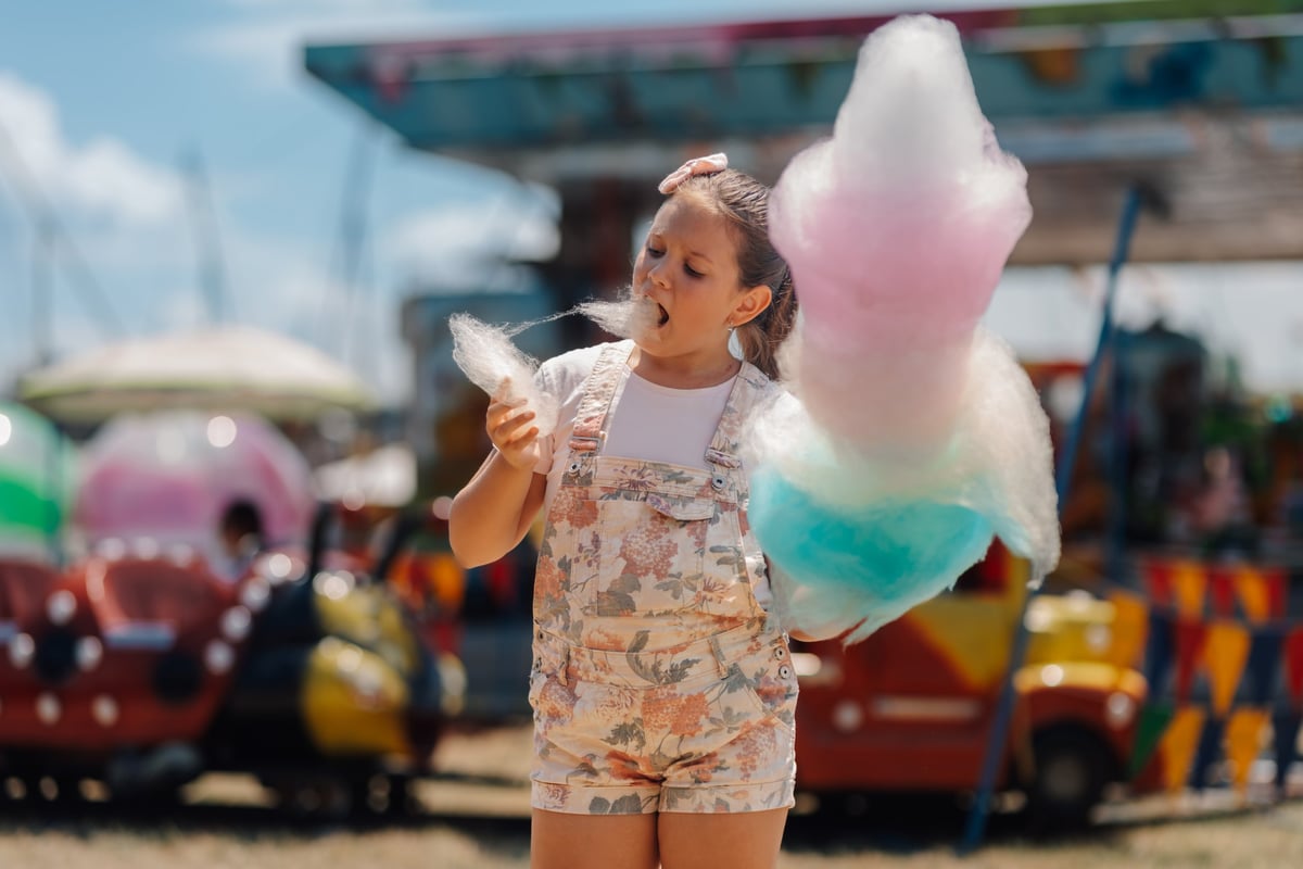 Girl enjoying cotton candy at fair