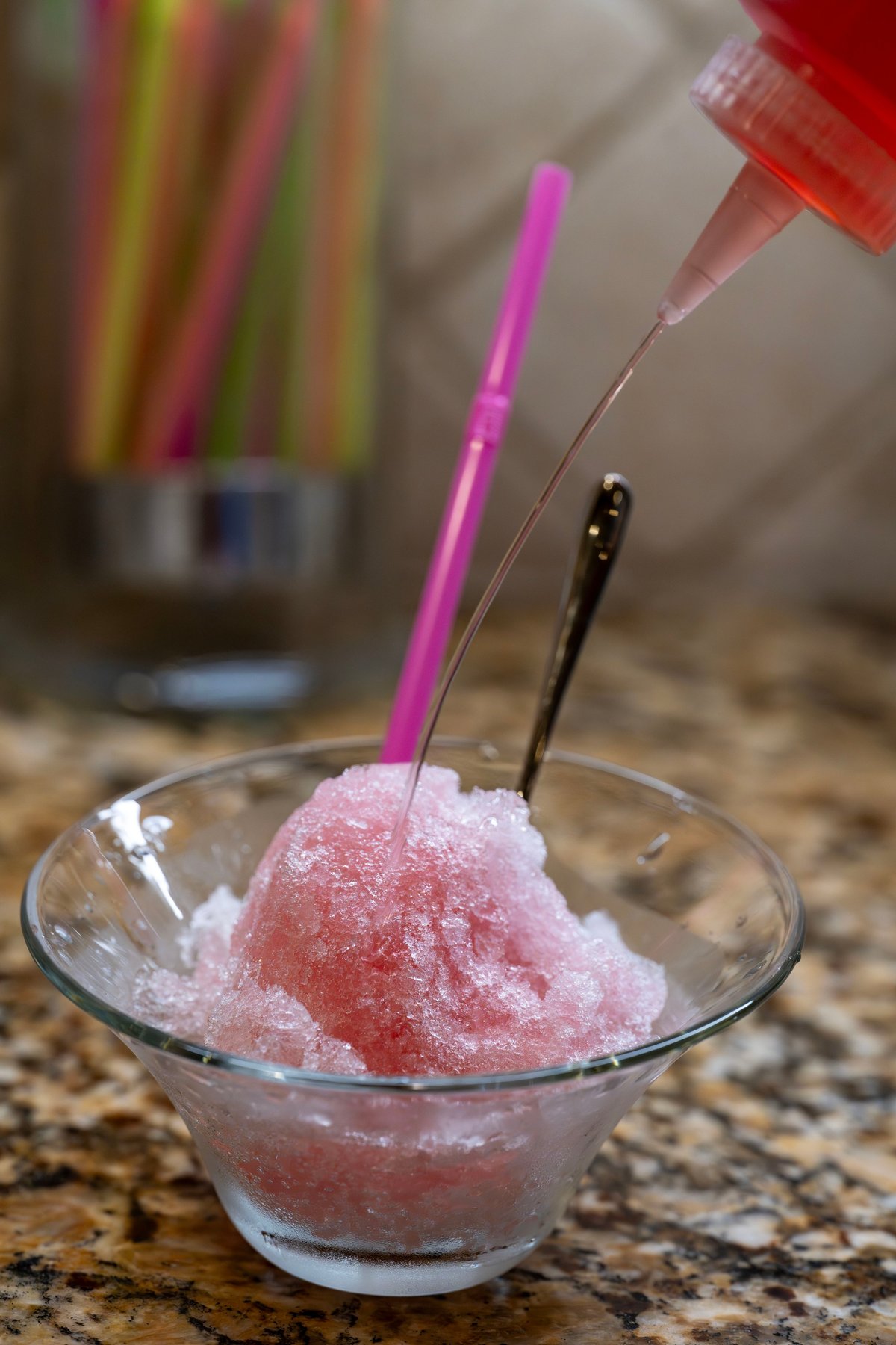 Shave ice being flavored with syrup