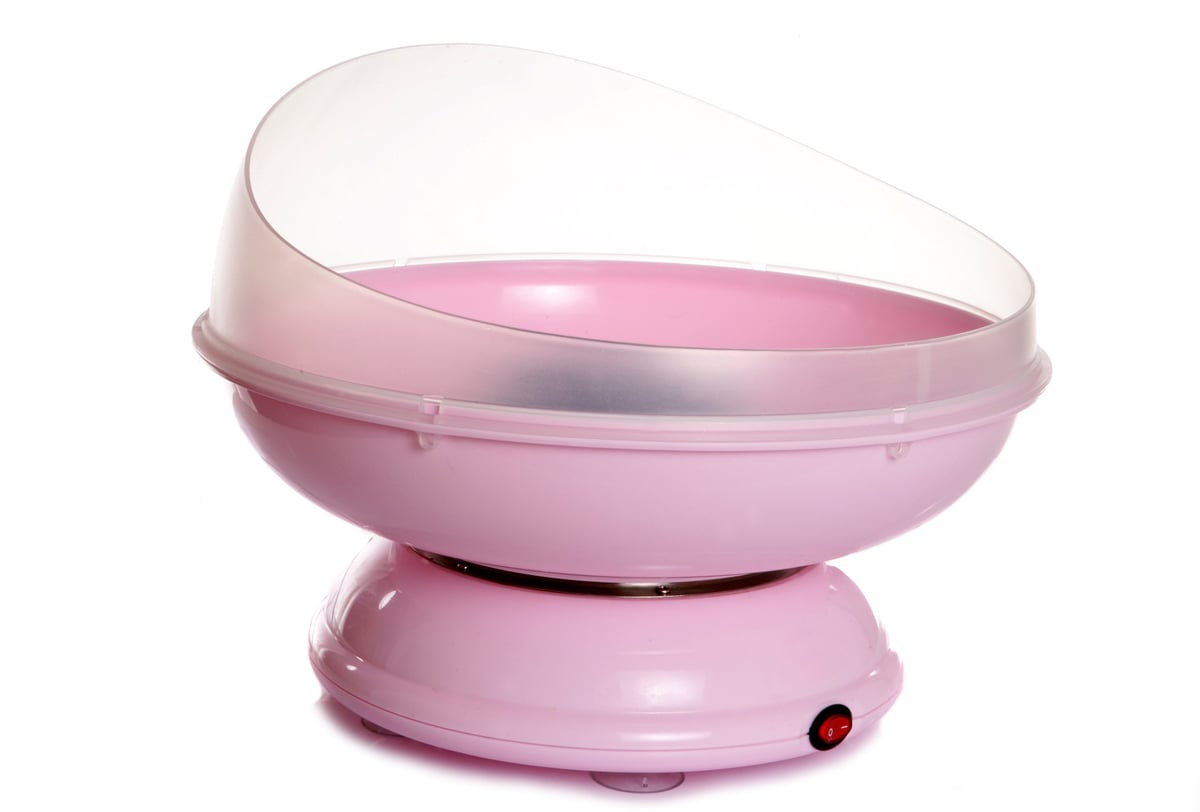 Colorful cotton candy machine spinning pink fluffy treats